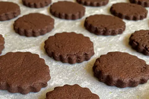 Deliziosi biscotti senza burro al cacao, con bordo ondulato, pronti per essere gustati.