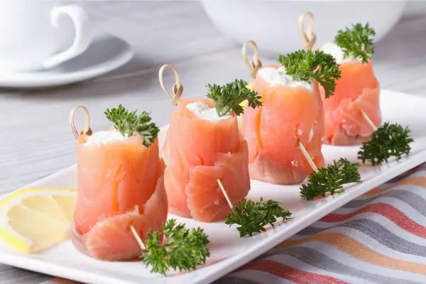 Rotolini di salmone affumicato con formaggio cremoso e prezzemolo, perfetti per ricette fredde.